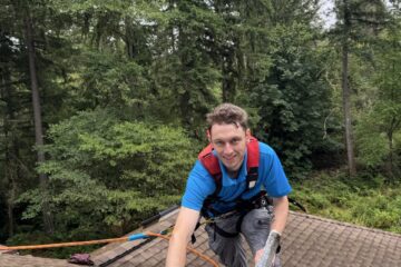 A Johnny Tsunami technician cleaning a skylight.