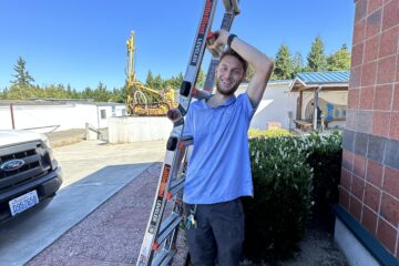 Technician carrying a ladder.